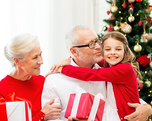 Image showing smiling family with gifts at home