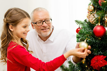 Image showing smiling family decorating christmas tree at home