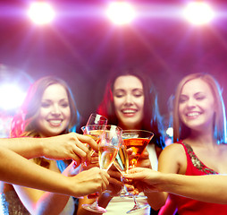 Image showing three smiling women with cocktails and disco ball