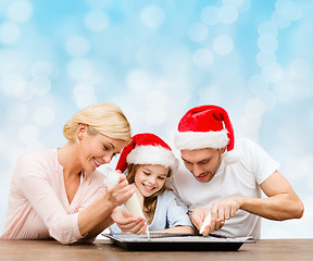 Image showing happy family in santa helper hats cooking