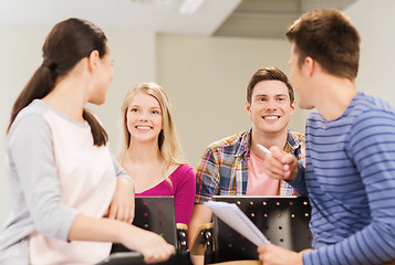 Image showing group of smiling students with notebook