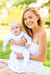 Image showing happy mother with little baby sitting on blanket