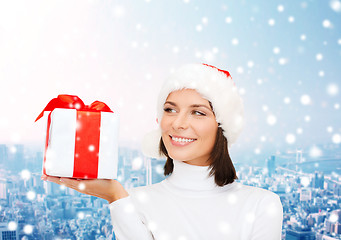 Image showing smiling woman in santa helper hat with gift box