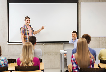 Image showing group of students and smiling teacher in classroom