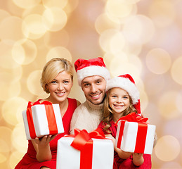 Image showing happy family in santa helper hats with gift boxes