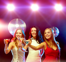 Image showing three smiling women with cocktails and disco ball