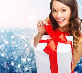 Image showing smiling woman in red dress with gift boxes