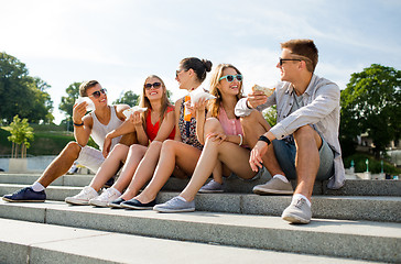 Image showing group of smiling friends sitting on city square