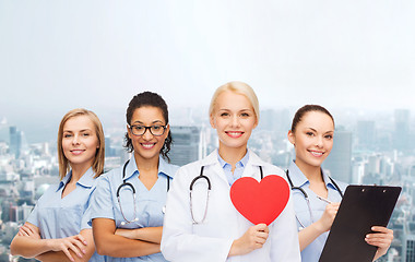 Image showing smiling female doctor and nurses with red heart