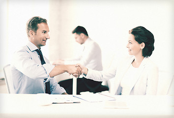 Image showing man and woman shaking hands in office