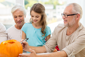 Image showing happy family sitting with pumpkins at home