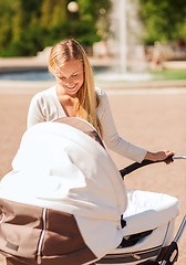 Image showing happy mother with stroller in park