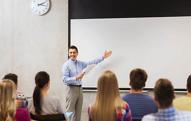 Image showing group of students and smiling teacher with notepad