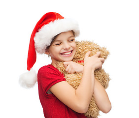 Image showing smiling girl in santa helper hat with teddy bear