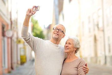 Image showing senior couple photographing on city street