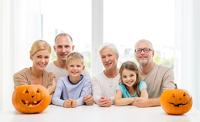 Image showing happy family sitting with pumpkins at home