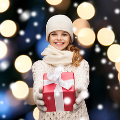 Image showing girl in hat, muffler and gloves with gift box