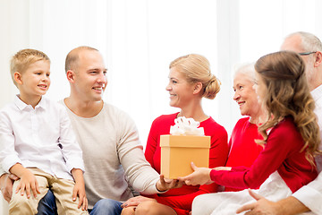 Image showing smiling family with gift at home