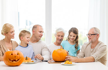 Image showing happy family sitting with pumpkins at home