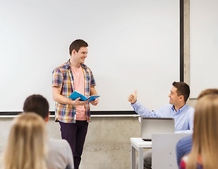 Image showing group of smiling students and teacher in classroom