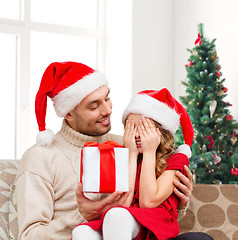 Image showing smiling daughter waiting for present from father