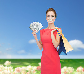 Image showing smiling woman in red dress with shopping bags