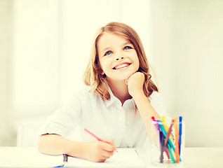 Image showing smiling little student girl drawing at school