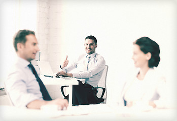 Image showing happy businessman showing thumbs up in office