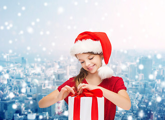 Image showing smiling girl in santa helper hat with gift box