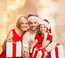 Image showing happy family in santa helper hats with gift boxes