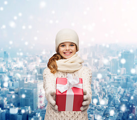 Image showing dreaming girl in winter clothes with gift box