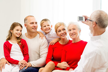 Image showing smiling family with camera at home