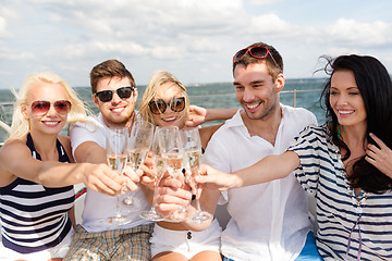 Image showing smiling friends with glasses of champagne on yacht