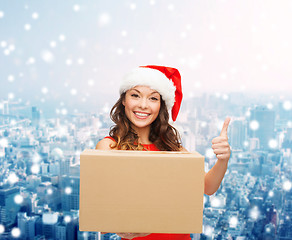 Image showing smiling woman in santa helper hat with parcel box