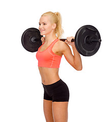 Image showing smiling sporty woman exercising with barbell