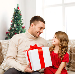 Image showing smiling father and daughter with gift box