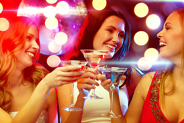 Image showing three smiling women with cocktails and disco ball