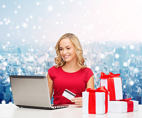 Image showing smiling woman with credit card and laptop