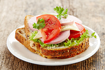 Image showing breakfast sandwich with sliced sausage and tomato