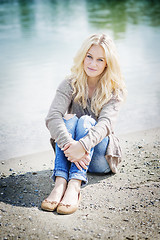 Image showing Blond woman sitting at lake