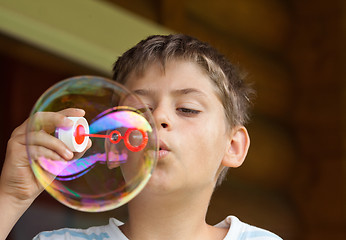 Image showing Boy blowing soap bubble