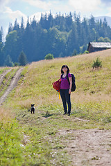 Image showing Woman hiking in mountains with dog