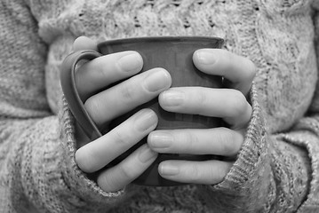 Image showing Two hands holding a mug of drink