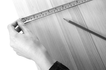 Image showing Using a steel tape measure on a wooden board 