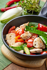 Image showing chicken breast meat and vegetables on frying pan