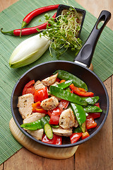 Image showing chicken breast meat and vegetables on frying pan