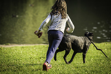 Image showing  young girl and dog on the grass