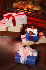 Image showing Christmas gifts near fireplace