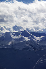 Image showing Evening sunlight mountain with clouds and silhouette of paraglid