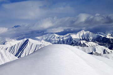 Image showing Top of off-piste snowy slope and cloudy mountains